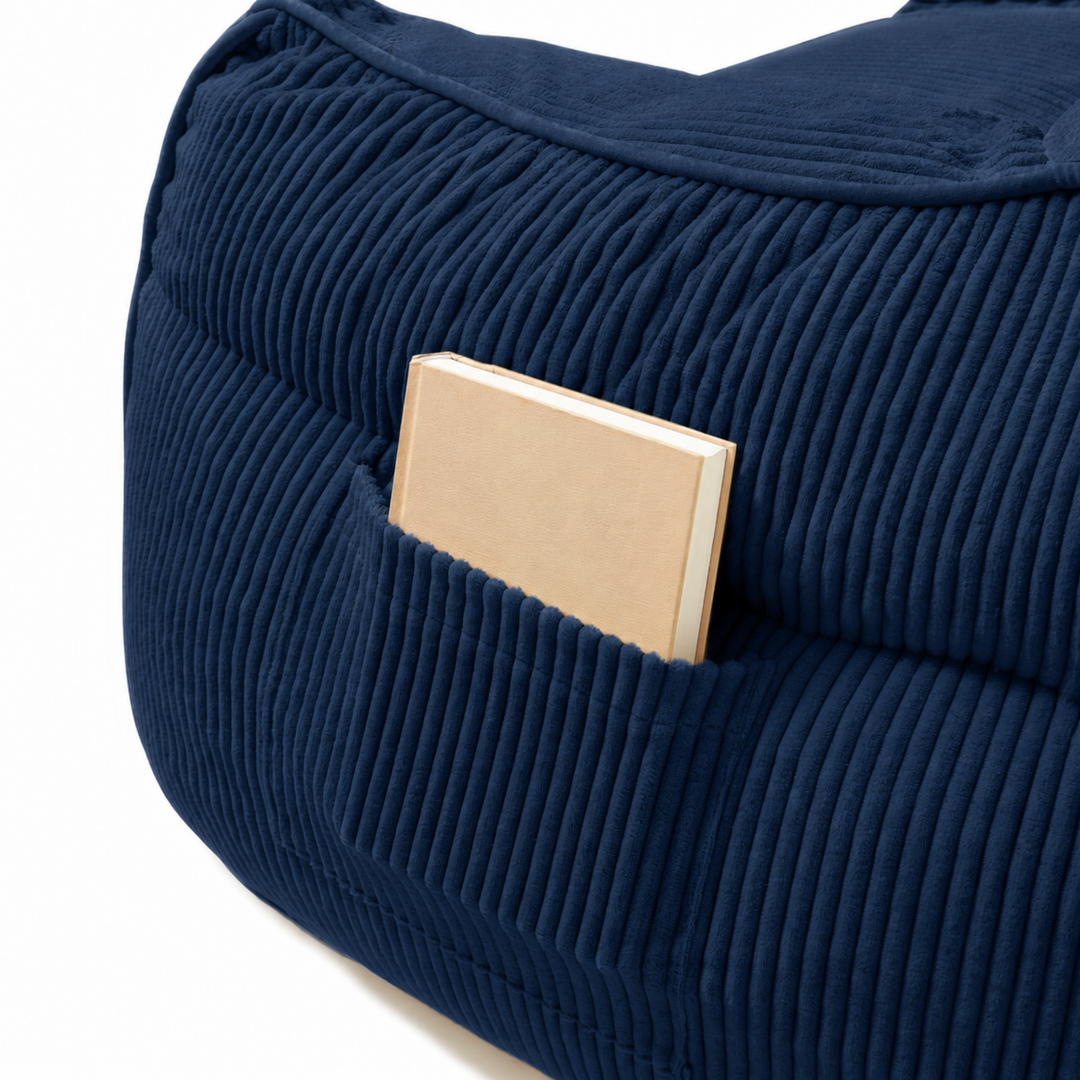 Pouf fauteuil en velours côtelé bleu foncé, détail de la poche de rangement sur le côté.