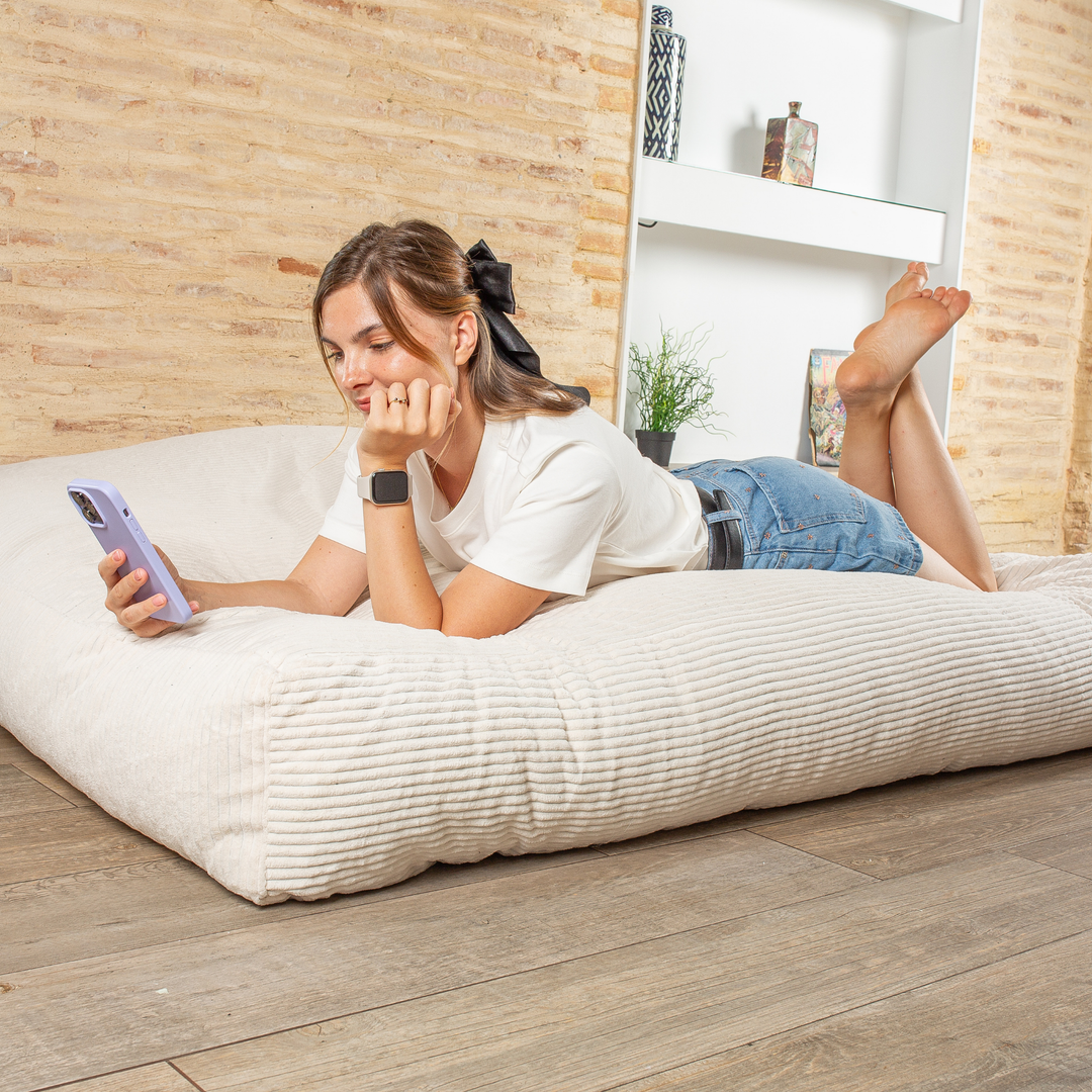 Personne allongée sur le pouf-lit convertible 2en1, utilisé en couchage pour se détendre