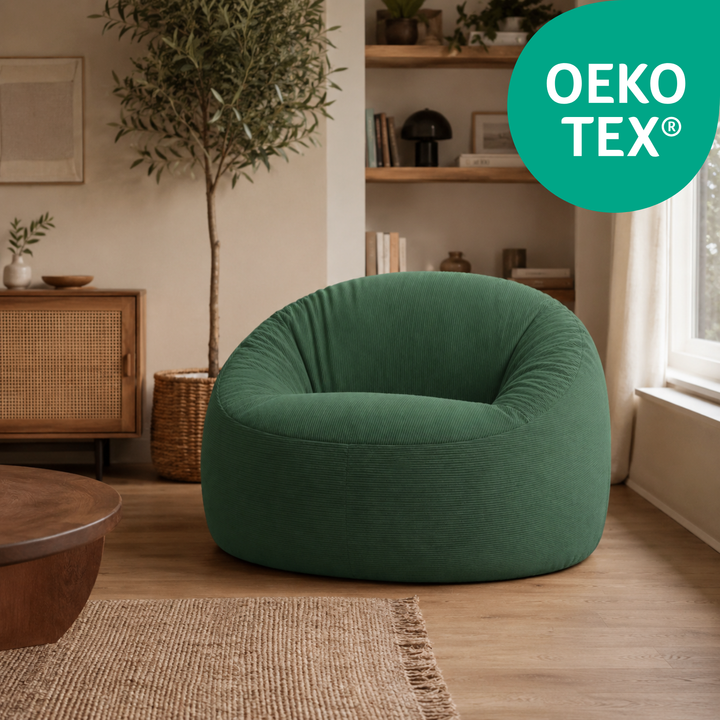 Pouf déhoussable en velours côtelé vert foncé, assise arrondie et capitonnée.