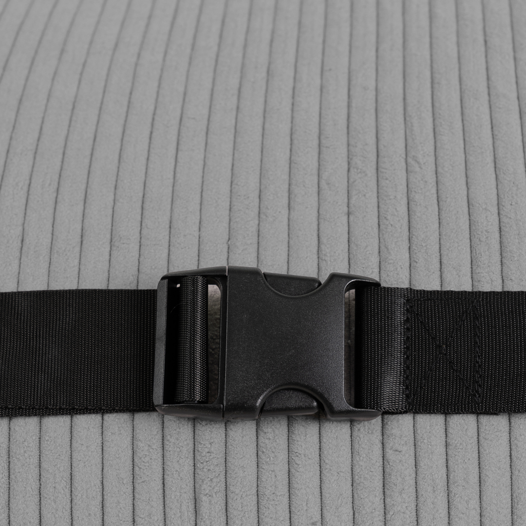 Sangle et boucle noires sur housse grise côtelée de chauffeuse d’appoint