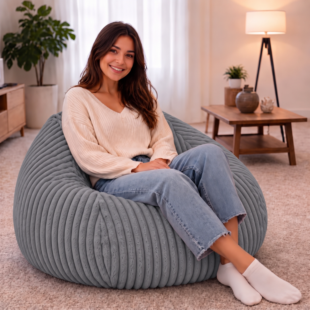 Personne assise confortablement dans un pouf poire en fourrure côtelée