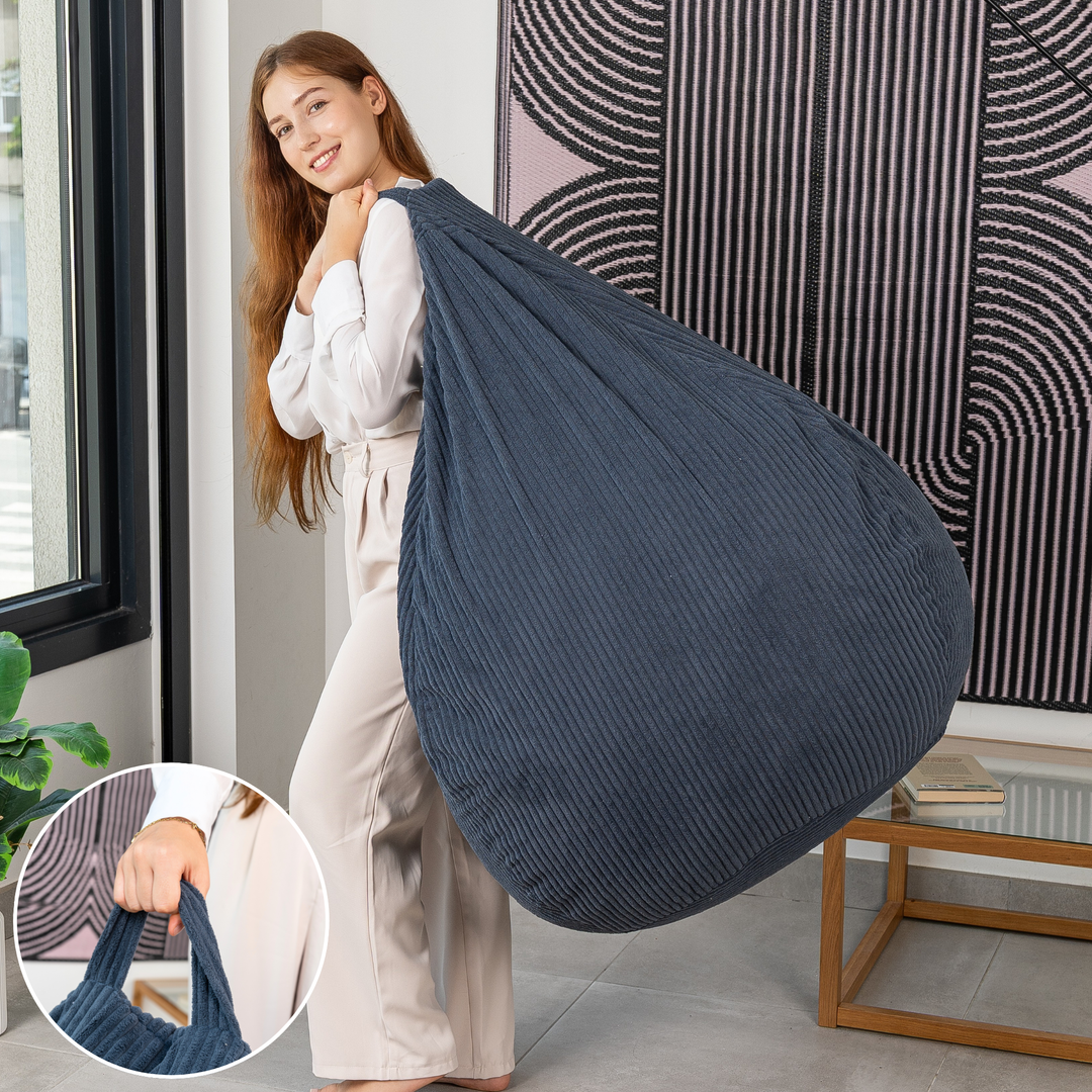 Femme soulevant le pouf poire déhoussable en velours côtelé déhoussable par sa poignée.