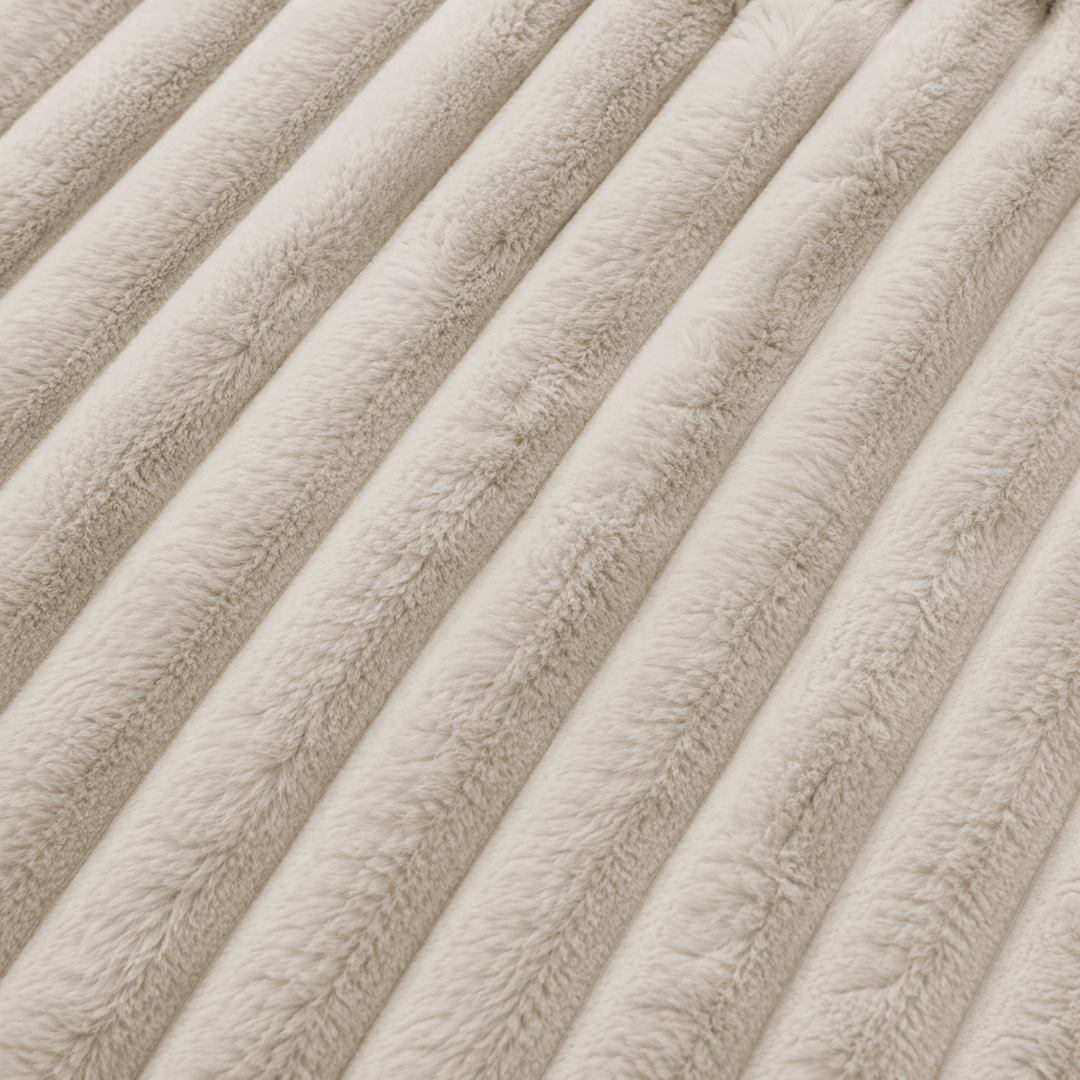 Tissu en fourrure côtelée beige, texture à relief visible.