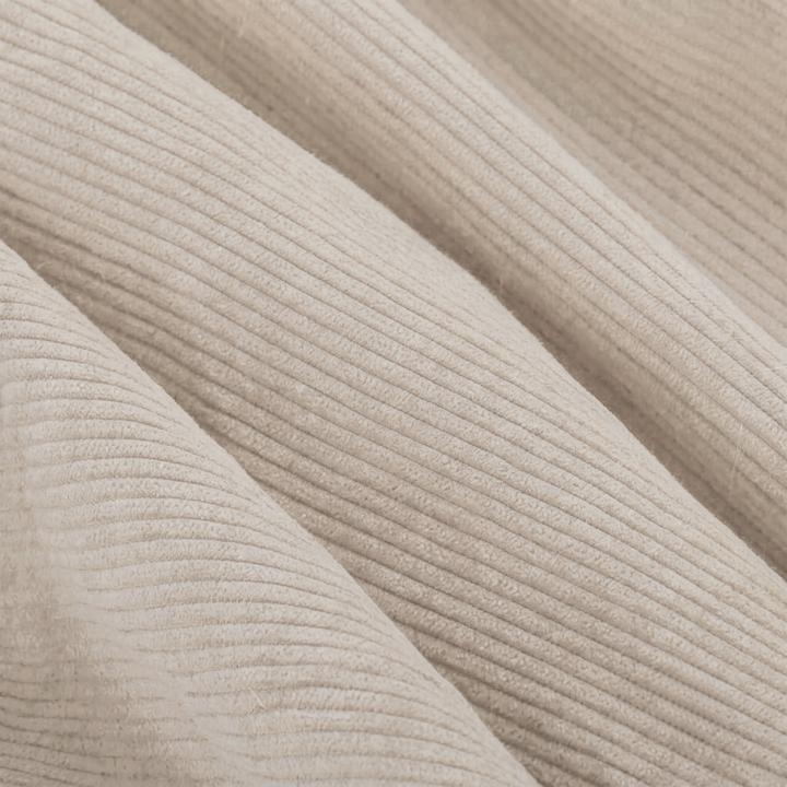 Tissu en velours côtelé écru, texture côtelée visible en gros plan.