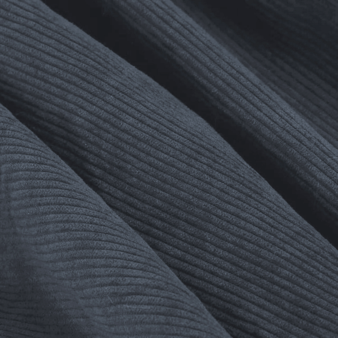 Détail du velours côtelé bleu nuit du pouf, texture en relief visible.
