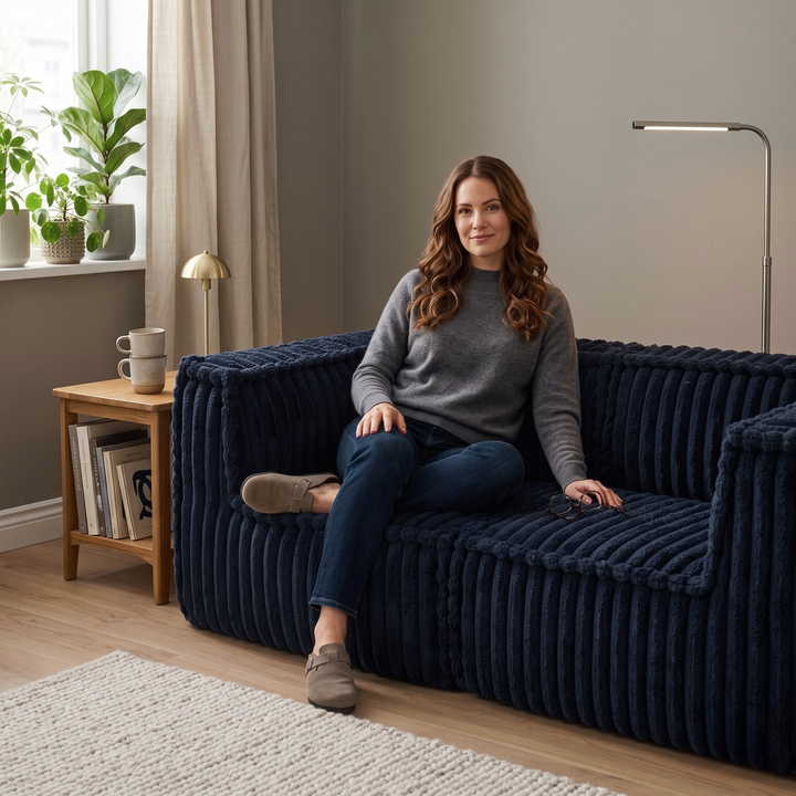 Femme assise sur le canapé modulable 2 places bleu en fourrure côtelée