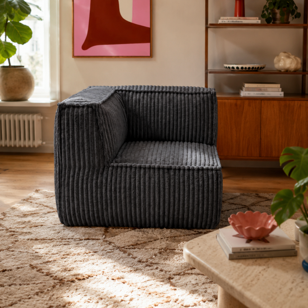 Module d’angle en velours côtelé gris foncé, assise avec accoudoir, dans un salon