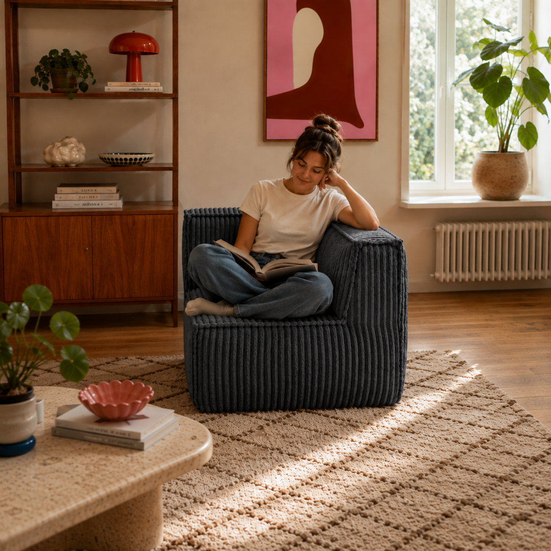 Personne assise sur le module d’angle de canapé en velours côtelé gris foncé, assise compacte pour coin